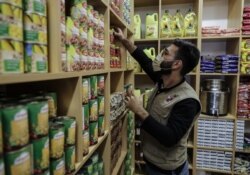FILE - A volunteer with the Lebanese NGO Beit al-Braka organizes food to be distributed to the needy, at the group's headquarters in the capital Beirut, February 23, 2021.