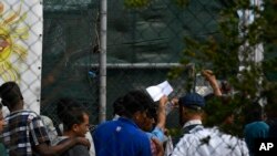 Migrants and refugees wait in a queue for the doctor at the Moria refugee camp on the northeastern Aegean island of Lesbos, Greece, Sept. 25, 2019.