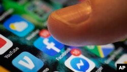 FILE - An iPhone displays the apps for Facebook and Messenger in New Orleans, Aug. 11, 2019. 