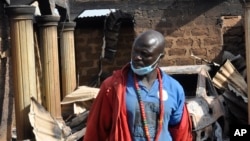 A man stands in front of a burned house on Dec. 26, 2023, following an attack by gunmen in Bokkos, Nigeria. Officials say at least 150 people were killed by gunmen who attacked remote villages in north-central Nigeria's Plateau state.