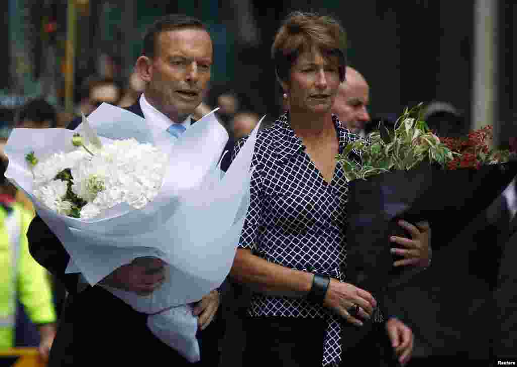 Australian Prime Minister Tony Abbott and his wife Margie prepare to place floral tributes near the cafe in central Sydney, December 16, 2014.