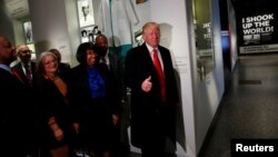 U.S. President Donald Trump (R) gives the thumb-up at the Dr. Ben Carson (2ndR) exhibit while visiting the National Museum of African American History and Culture in Washington, Feb. 21, 2017.