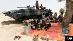 Des soldats tchadiens prient à côté d'un véhicule blindé près de Malam Fatori, Nigeria, 3 avril 2015.