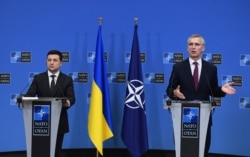 FILE - Ukrainian President Volodymyr Zelenskiy, left, and NATO Secretary General Jens Stoltenberg are seen during a press conference after their bilateral meeting at European Union headquarters in Brussels, Belgium, Dec. 16, 2021.