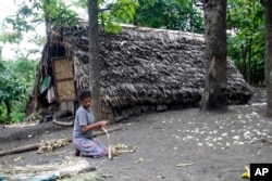 FILE - A woman weaves a mat in a village on Tanna Island in Vanuatu, June 2, 2015. Tanna Island was particularly hard hit by Cyclone Pam, which struck in March of that year. Many people in Vanuatu believed the cyclone was a manifestation of climate change.