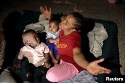 A migrant woman reacts inside a shelter after it was hit by a shrapnel from an air strike, in Tripoli, Libya May 8, 2019.