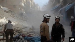 In this picture provided by the Syrian Civil Defense group known as the White Helmets, Syrian Civil Defense workers search through the rubble in rebel-held eastern Aleppo, Syria, Oct. 12, 2016. The situation in Aleppo is among the focal points of the Lausanne talks.