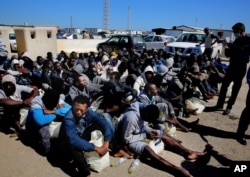 African illegal migrants wait to receive medial assistance after being rescued by coast guards, in Tripoli, Libya, April 11, 2016. More than 100 migrants were rescued by two coastal guards on Monday after their boat started sinking in the sea.