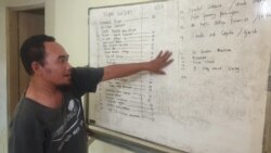 Fatkhul Khoir dari KontraS Surabaya menunjukkan daftar pengunjuk rasa RUU Cipta Kerja yang diamankan polisi, di Surabaya, Jawa Timur, Kamis, 15 Oktober 2020. (Foto: Petrus Riski/VOA)