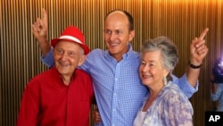 Juris, left, and Lois Greste, parents of Australian journalist Peter Greste, and his brother Andrew, center, pose for the media at a press conference in Brisbane, Australia, Monday, Feb. 2, 2015.
