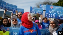 FILE -- Protesters stand across the street from a Donald Trump rally holding "Muslims for Peace" signs before a campaign rally in Orlando, Florida
