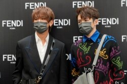 FILE - Keung To, left, and Ian Chan, members of the Cantopop band Mirror, pose for a photo during a promotional event of a luxury store in Hong Kong, July 22, 2021.