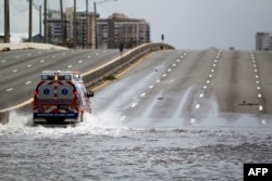 An ambulance drives on a flooded street in the aftermath of Hurricane Maria in San Juan, Puerto Rico, Sept. 22, 2017.