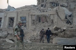 Afghan security forces and NATO troops investigate at the site of explosion near the German consulate office in Mazar-i-Sharif, Afghanistan, Nov. 11, 2016.
