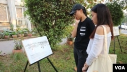 អ្នកចូលរួម​កំពុង​មើល​រូប​ថត​ដែល​រៀបរាប់​អំពី​ទីតាំង​បន្សល់ពីសម័យ​ខ្មែរ​ក្រហម ក្នុង​ពិធី​សម្ពោធ​គម្រោង​កម្មវិធី​ទូរសព្ទ និង​គេហទំព័រ​ស្តីអំពី​រឿងរ៉ាវ និង​ប្រវត្តិ​នៃ​ទីតាំង​សំខាន់ៗ​ក្នុង​របប​ខ្មែរ​ក្រហម ដែល​មាន​ឈ្មោះ​ថា​ «ទីចងចាំ» ឬ​ «Mapping Memories Cambodia នៅសាកលវិទ្យាល័យភូមិន្ទភ្នំពេញ កាលពីថ្ងៃទី២ ខែកុម្ភៈ ឆ្នាំ២០១៩។