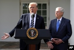 President Donald Trump answers questions with Senate Majority Leader Mitch McConnell, R-Ky., in the Rose Garden at the White House, Oct. 16, 2017.