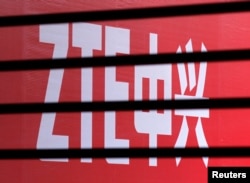 The company logo of ZTE is seen through a wooden fence on a glass door in Beijing, April 18, 2013.