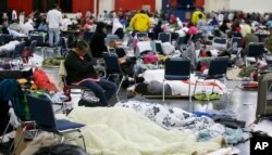 People rest at the George R. Brown Convention Center that has been set up as a shelter for evacuees escaping the floodwaters from Tropical Storm Harvey in Houston on Tuesday, Aug. 29, 2017.