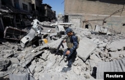 FILE - A member of Iraqi federal police patrols in the destroyed Old City of Mosul, Iraq, Aug. 7, 2017.