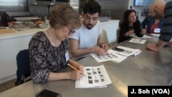 Edible Alphabet students discuss pizza toppings with a partner whose native tongue is different from their own.