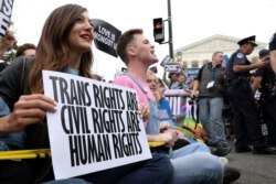 LGBT activists and supporters block the street outside the U.S. Supreme Court as it hears arguments in a major LGBT rights case.