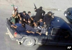 Gunmen drive away with about a dozen men, two in camouflage police uniforms, in Arsal, a Sunni Muslim town near the Syrian border in eastern Lebanon, Aug 2, 2014.