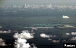 FILE - An aerial photo taken though the window of a Philippine military plane shows the land reclamation by China on Mischief Reef in the Spratly Islands in the South China Sea, west of Palawan, Philippines, May 11, 2015.