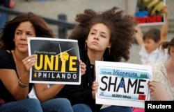 Two woman hold protest signs in support of Philando Castile during a rally on the capitol steps after a jury found St. Anthony Police Department officer Jeronimo Yanez not guilty of second-degree manslaughter in the death of Castile, in St. Paul, Minnesota.