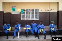 Health care workers rest outside a Red Cross facility in the town of Koidu in eastern Sierra Leone, Dec. 19, 2014.
