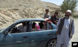 An Afghan family, who have escaped from the volatile Ghazni province, stop at a checkpoint in Maidan Shar, west of Kabul, Aug. 13, 2018.