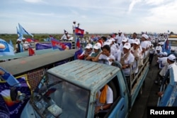FILE - Supporters of the Cambodian People's Party stand on a truck as they are surrounded by supporters of the Cambodia National Rescue Party during a local election campaign in Phnom Penh, May 20, 2017.