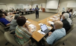 In this, Wednesday, Feb. 12, 2020 photo, Vincent Keeys, standing, president of the NAACP in Collier County, talks to a group of nonprofit leaders and government agencies about the Census undercount in 2010, in Immokalee, Florida.