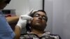 FILE - A man has acne removed from his face with a laser at a clinic in Baghdad, Iraq, June 2, 2015. Researchers have found that cream personalized with a person's own "good" bacteria may help ward off "bad" bacteria. 