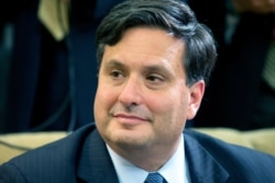 FILE - In this Oct. 22, 2014 file photo, Ebola coordinator Ron Klain listens as President Barack Obama speaks to the media about the government's Ebola response in the Oval Office of the White House in Washington.