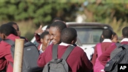 Des écoliers s'embrassent le dernier jour d'école à Harare, au Zimbabwe, le mardi 24 mars 2020. (AP Photo/Tsvangirayi Mukwazhi)