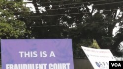 A supporter for Malawi's ruling party carries a placard which denounces the verdict by the Constitutional Court which nullifed the May presidential elections, in Blantyre, Feb. 17, 2020. (Lameck Masina/VOA)