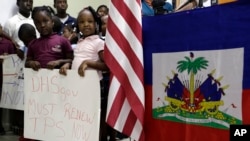 FILE – Standing near U.S. and Haitian flags, youngsters advocate for renewing Temporary Protected Status (TPS) for Central American and Haitian immigrants, at a news conference in Miami, Fla., Nov. 6, 2017.