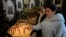 A Syrian Christian woman lights a candle during the first Sunday Mass since Syrian President Bashar al-Assad's ouster, at Mariamiya Orthodox Church in Old Damascus, Syria, Dec. 15, 2024.