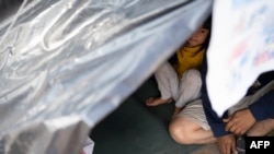 Una familia no identificada del estado de Michoacán se sienta en su carpa cerca del Puente Córdoba de las Américas en Ciudad Juárez, México, el 10 de diciembre de 2019.