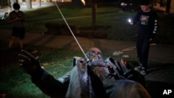 Orang-orang merekam patung Albert Pike yang dirobohkan dan dibakar oleh pedemo anti-rasisme di Washington D.C., 20 Juni 2020. Patung itu adalah satu-satunya patung jenderal Konfederasi yang ada di ibu kota AS.