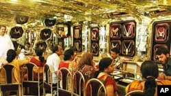 Customers look at gold jewelry at a shop on the occasion of a Hindu festival 'Akshay Tritiya' in Allahabad, India, 16 May 2010