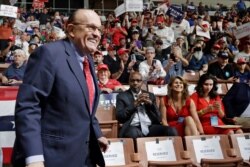 FILE - President Donald Trump's personal attorney Rudy Giuliani smiles as he arrives at Trump's campaign rally in Manchester, New Hampshire, Aug. 15, 2019.