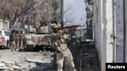 FILE - A member of Libyan National Army fires a weapon during clashes with Islamist militants in the militants' last stronghold in Benghazi, Libya, July 6, 2017.
