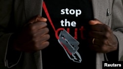 FILE - A man's T-shirt reads "Stop the Cut" referring to Female Genital Mutilation during a social event advocating against such harmful practices at the Imbirikani Girls High School in Imbirikani, Kenya, April 21, 2016.