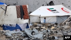 A Palestinian child walks amid rubble at a makeshift camp housing displaced Palestinians in Rafah, Gaza Strip, on Jan. 28, 2024,