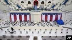 A law enforcement official sweeps a spectator seating area as preparations take place for President-elect Joe Biden's inauguration ceremony at the U.S. Capitol in Washington, Saturday, Jan. 16, 2021. (AP Photo/Patrick Semansky)