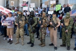 FILE - People, including activists with the Boogaloo movement, rally at the State House in Concord, New Hampshire, May 2, 2020, in a protest unrelated to the George Floyd demonstrations.