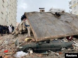 Orang-orang mencari korban di antara puing-puing setelah gempa bumi di Diyarbakir, Turki, 6 Februari 2023. (Foto: REUTERS/Sertac Kayar)