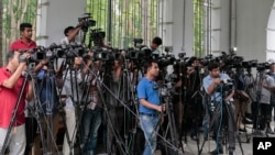 FILE - Reporters cover proceedings outside a court in Dhaka, Bangladesh.