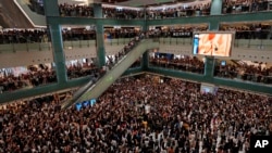Local residents sing a theme song written by protesters ‘Glory be to Thee’ at a shopping mall in Hong Kong, Sept. 11, 2019. 